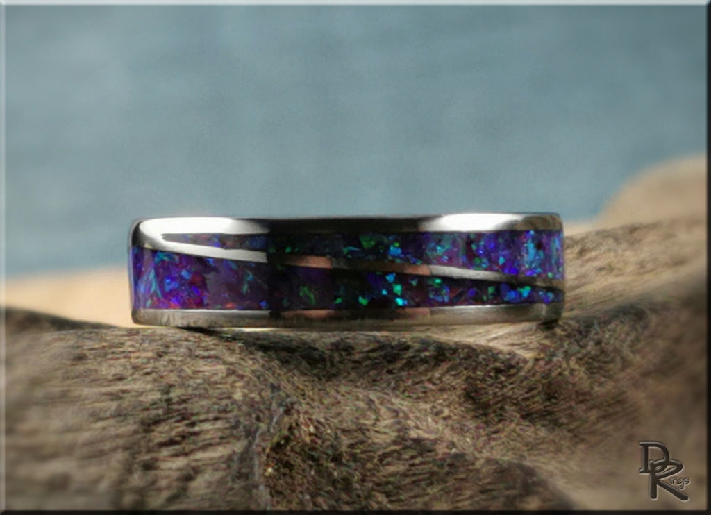 DR Rings titanium ring with opal inlay featuring vibrant blue and green colors on textured surface