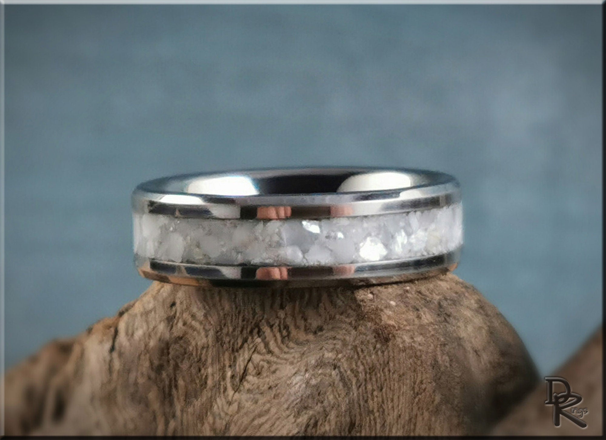 DR Rings tungsten ring with pearl inlay featuring a polished silver band on wooden surface