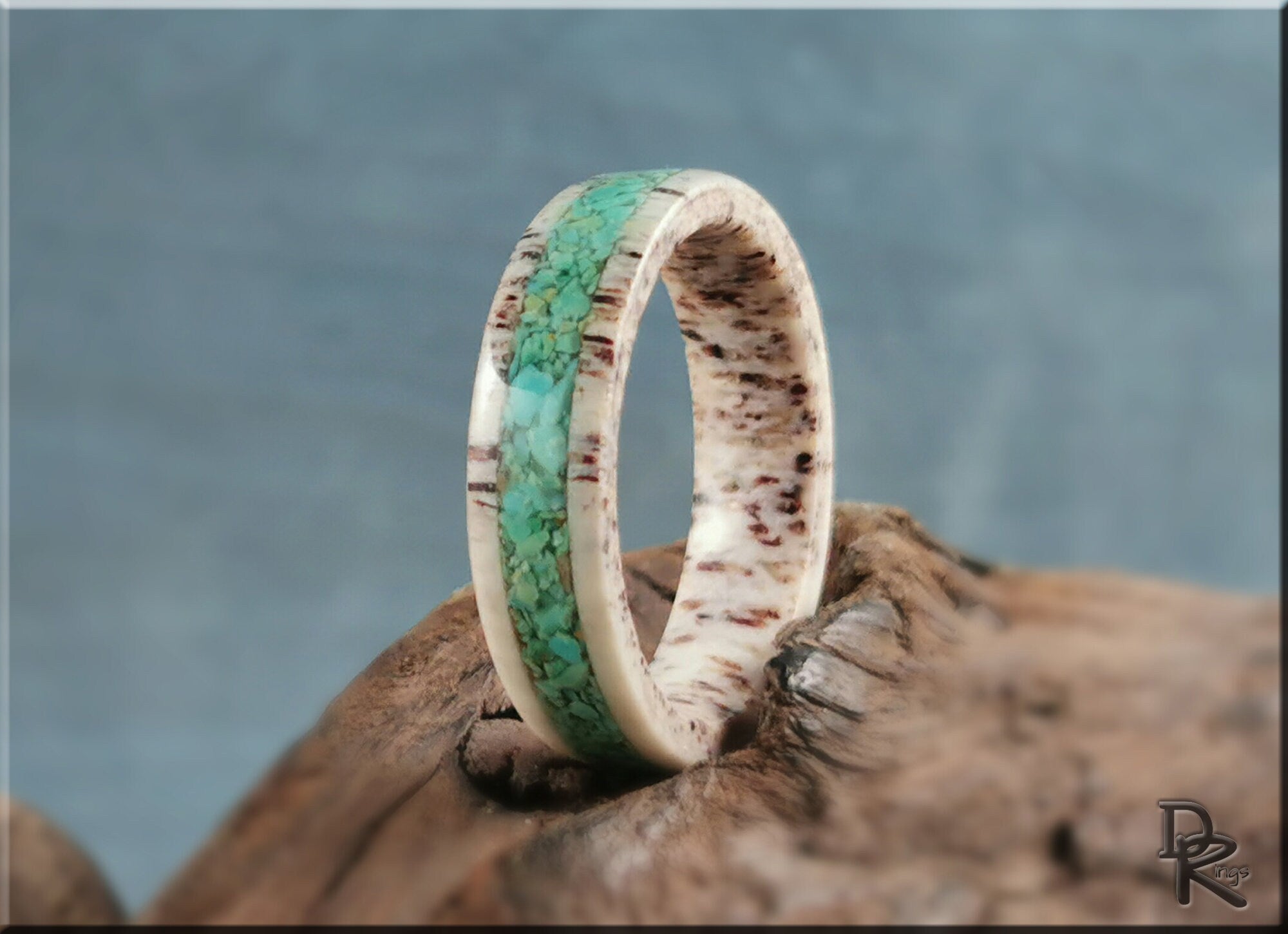 Antler ring with turquoise inlay by DR Rings displayed on rustic wood background