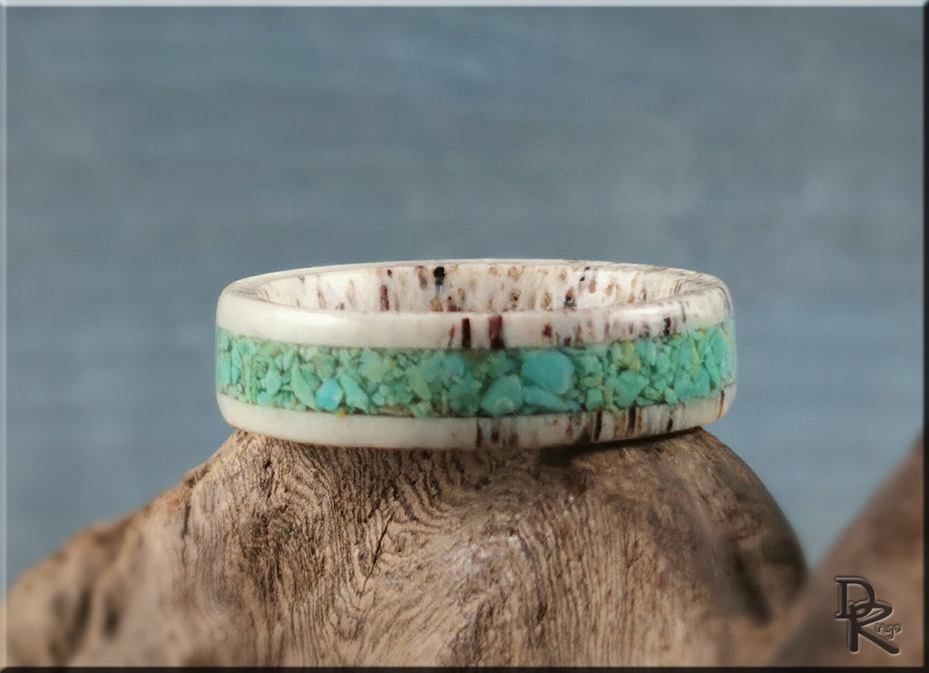 Antler ring with turquoise inlay by DR Rings on a wooden surface with a blue background