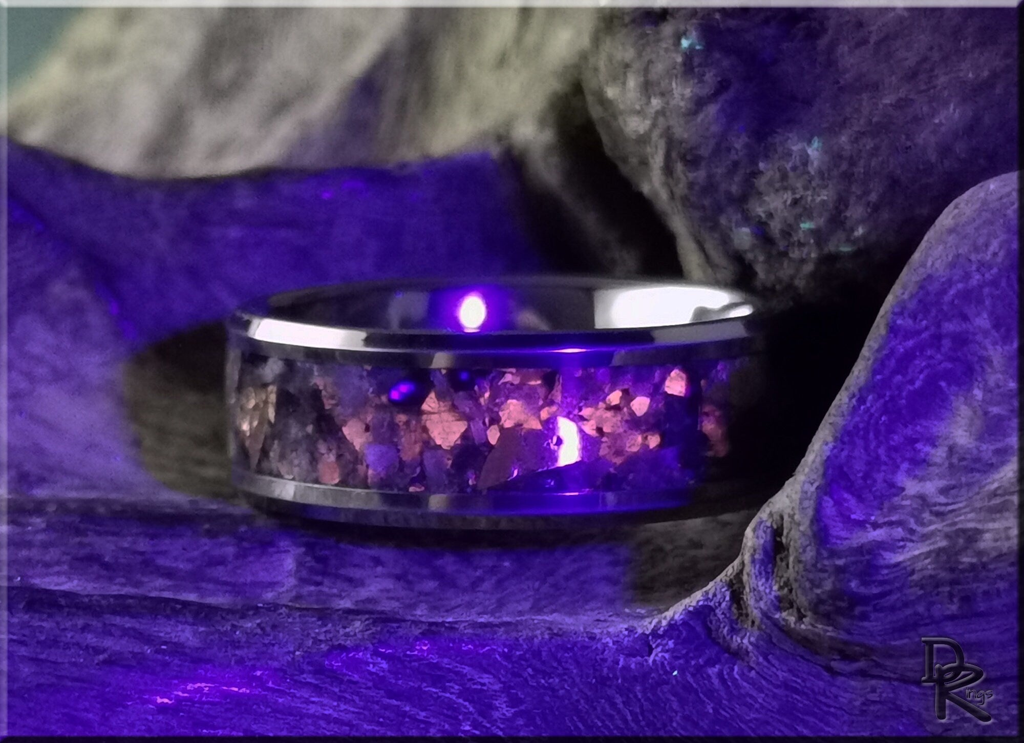 Tungsten ring carbide with yooperlite stone inlay glowing under purple light