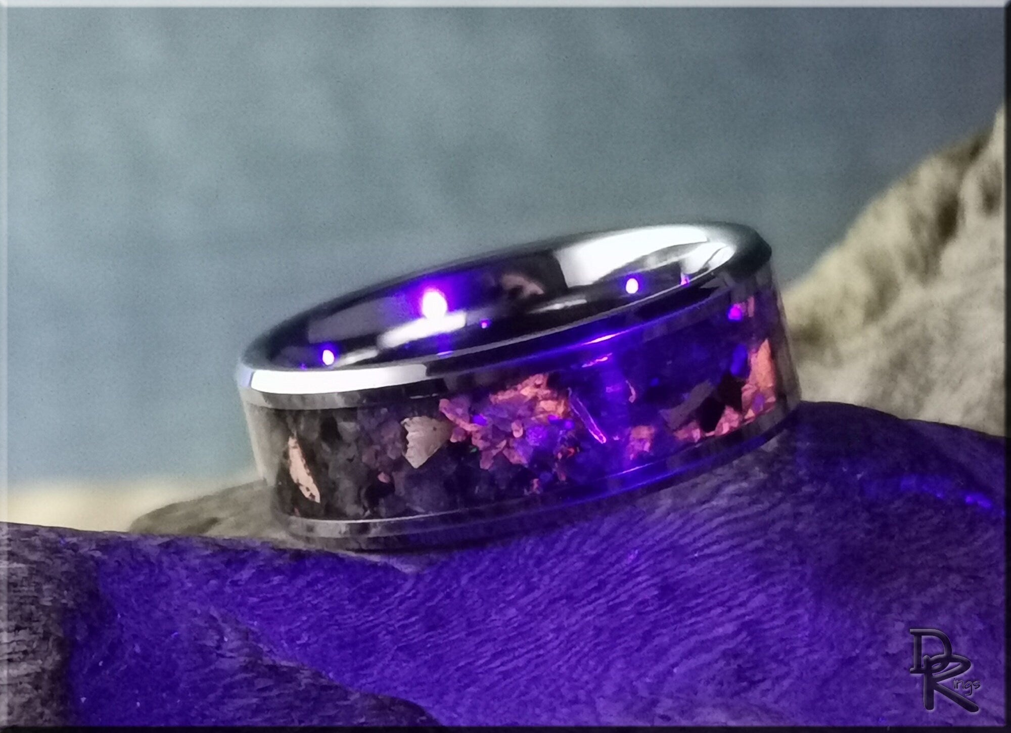 Tungsten ring carbide with yooperlite inlay by DR Rings on purple surface with glowing stones
