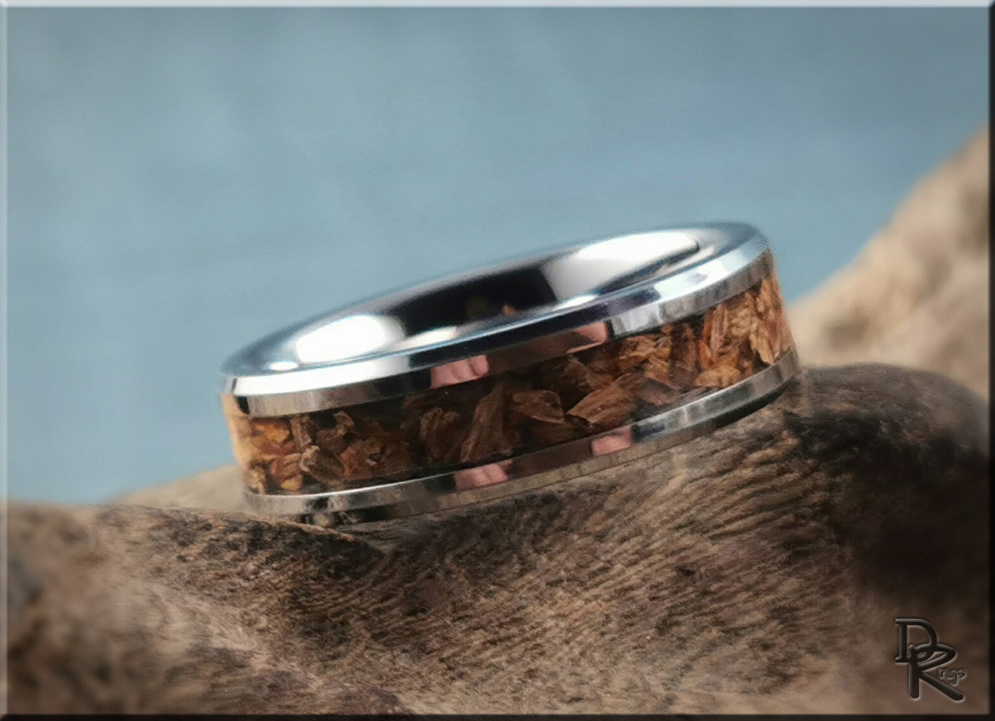 Tungsten ring with dinosaur bone inlay by DR Rings featuring polished silver edges and unique natural texture