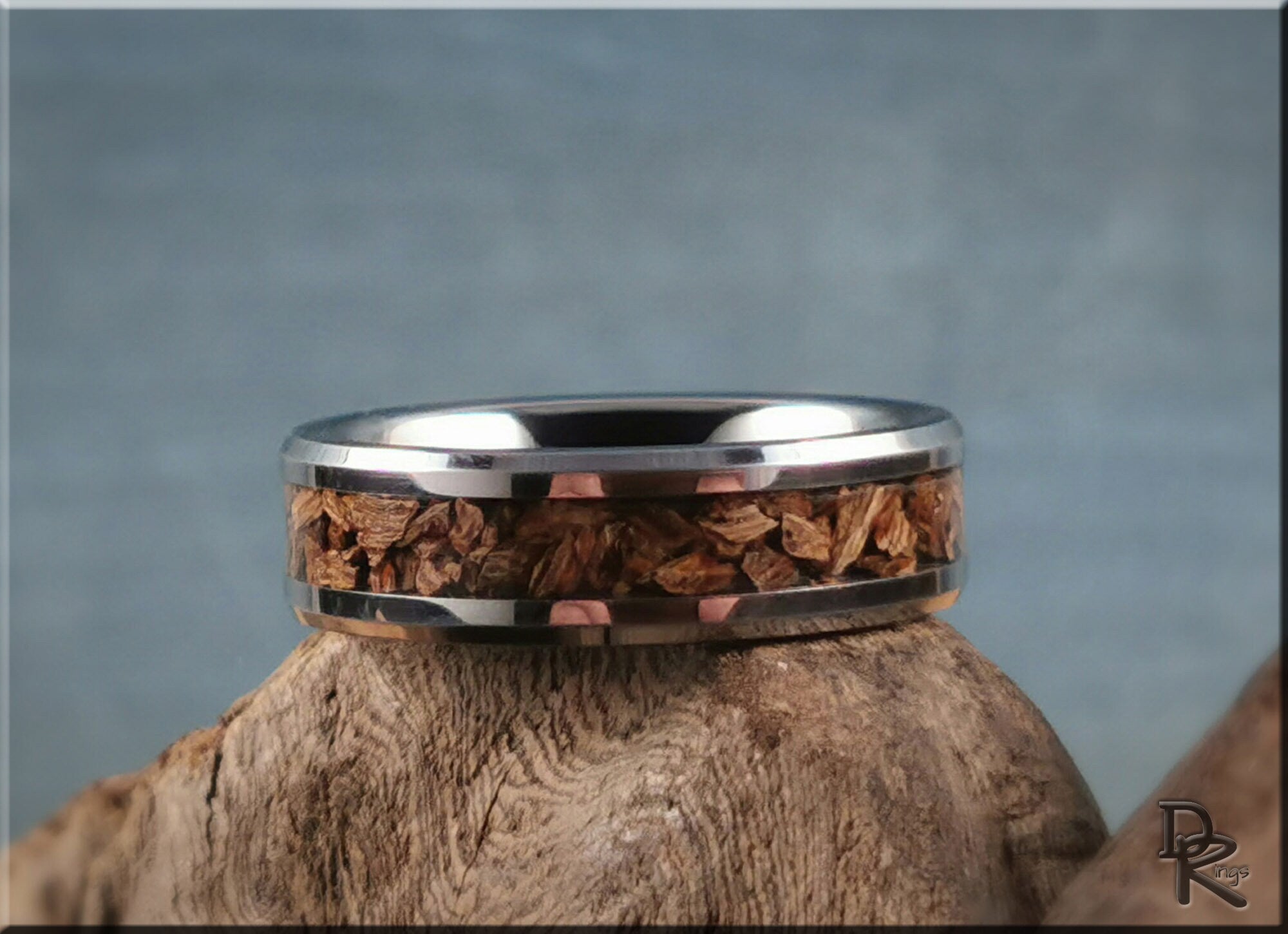 DR Rings tungsten ring with dinosaur bone inlay handcrafted on natural wood background