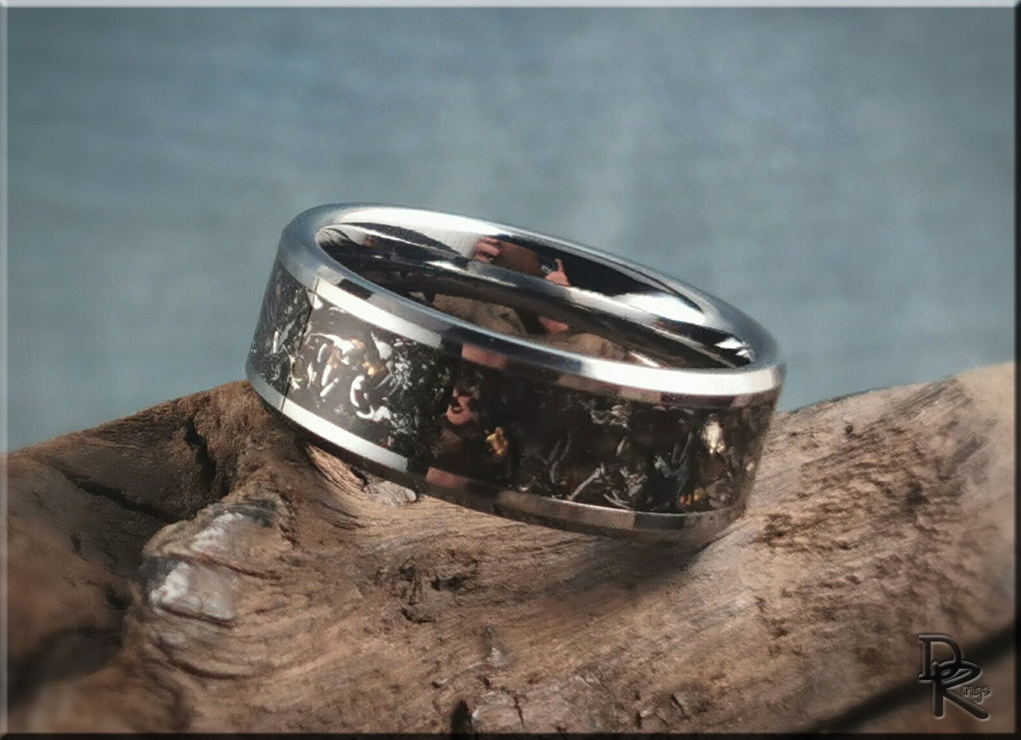 Tungsten ring with meteorite inlay by DR Rings resting on textured wood background