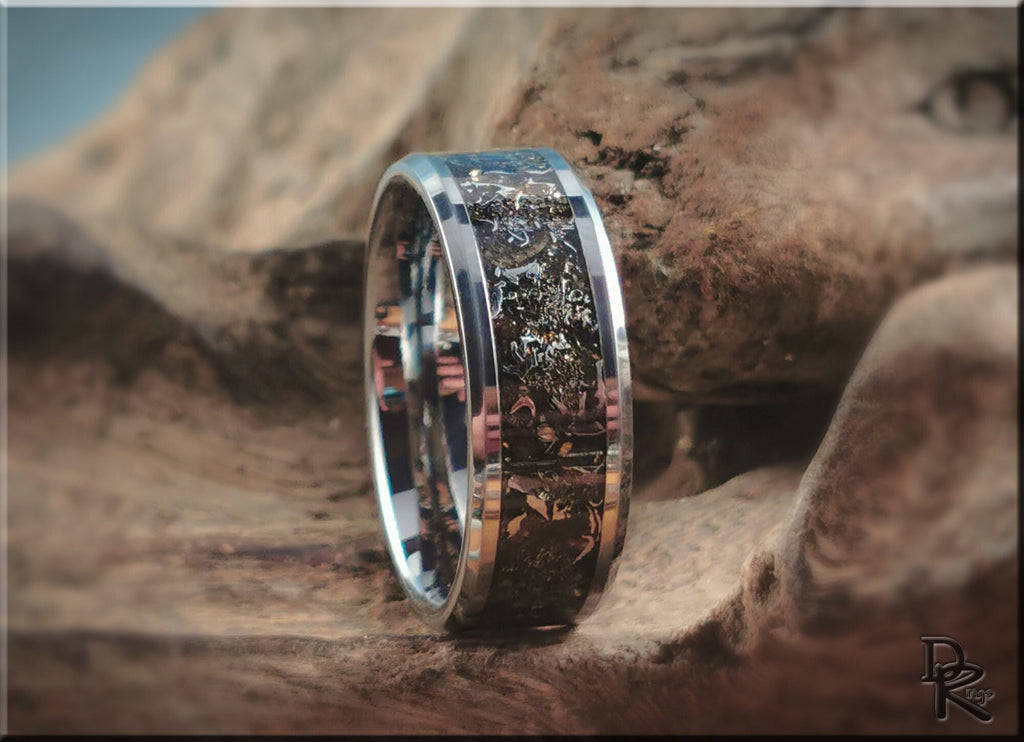Tungsten ring with meteorite inlay by DR Rings with polished silver edges on rustic background