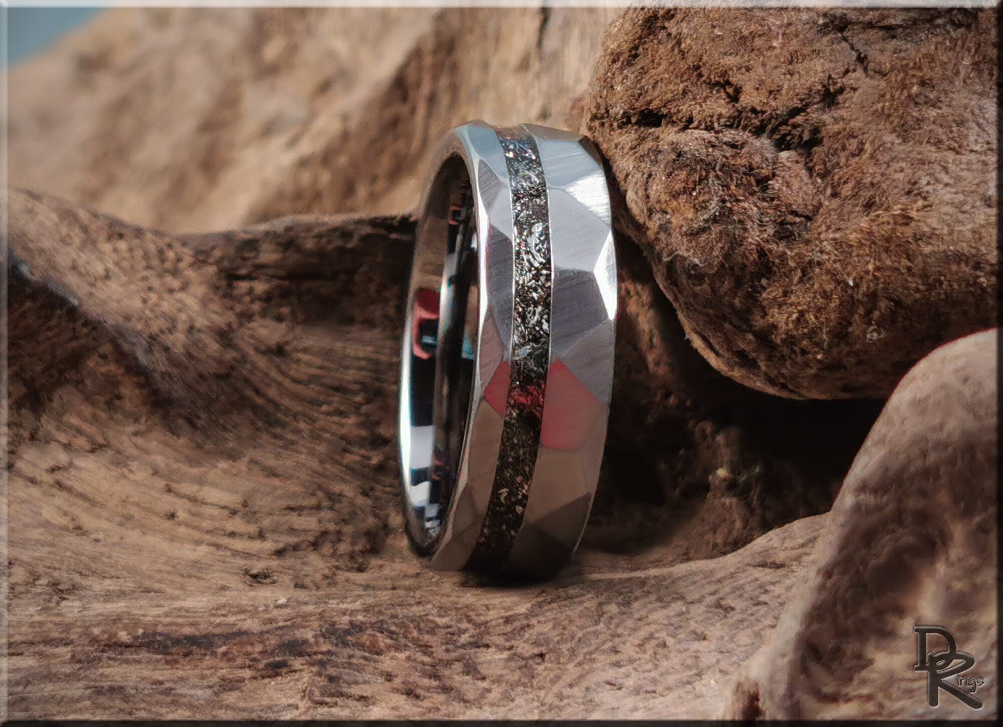 Hammered tungsten carbide ring with meteorite inlay displayed on natural textured wood background by DR Rings