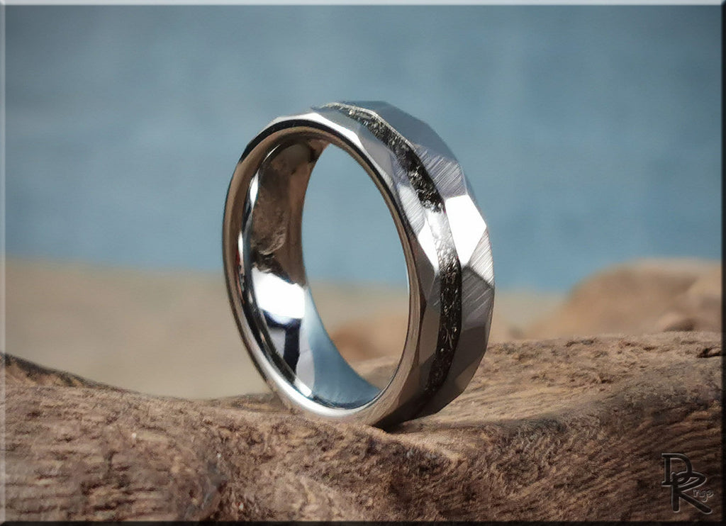 Hammered tungsten carbide ring with meteorite inlay displayed on rustic wood surface
