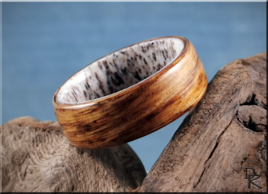 Oak wood ring on antler displayed on rustic wooden surface by DR Rings