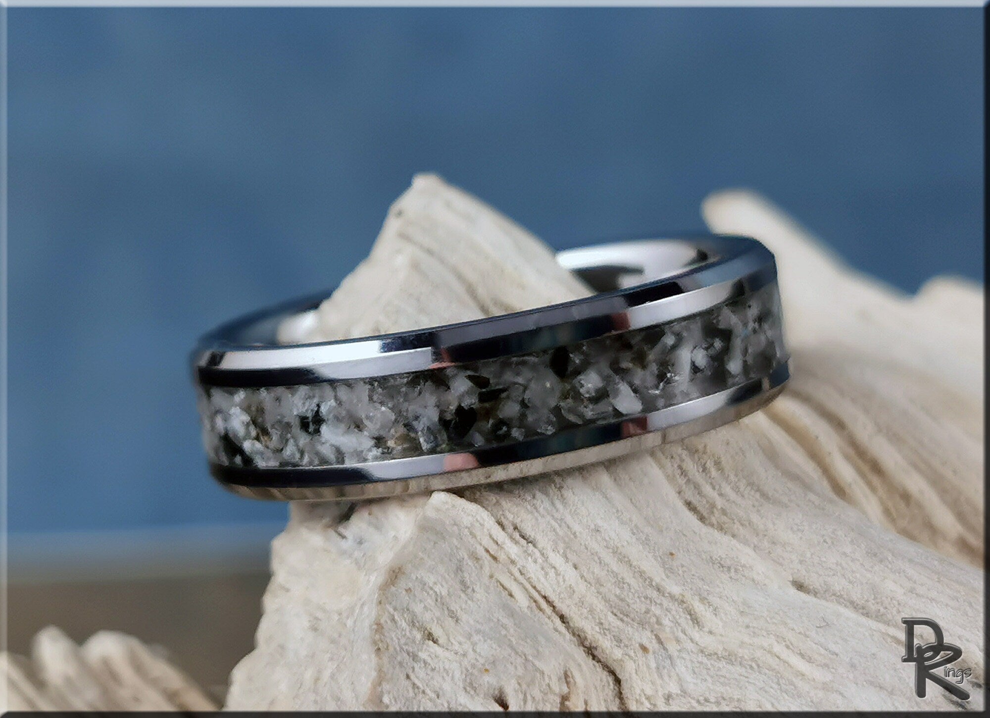 Tungsten ring with moonstone inlay featuring a polished silver-toned band on natural wood background