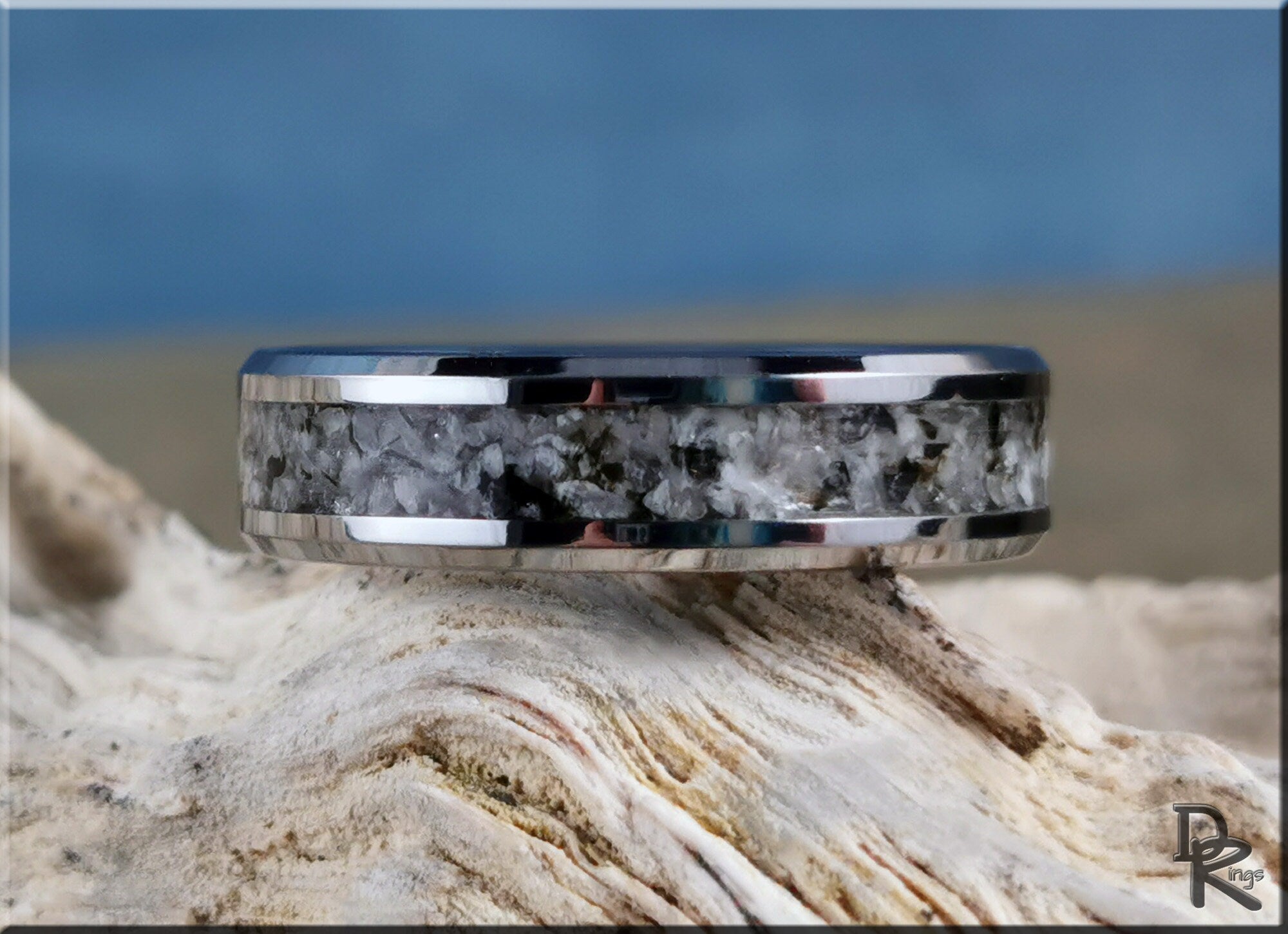 DR Rings tungsten ring with moonstone inlay featuring a polished silver edge on natural background