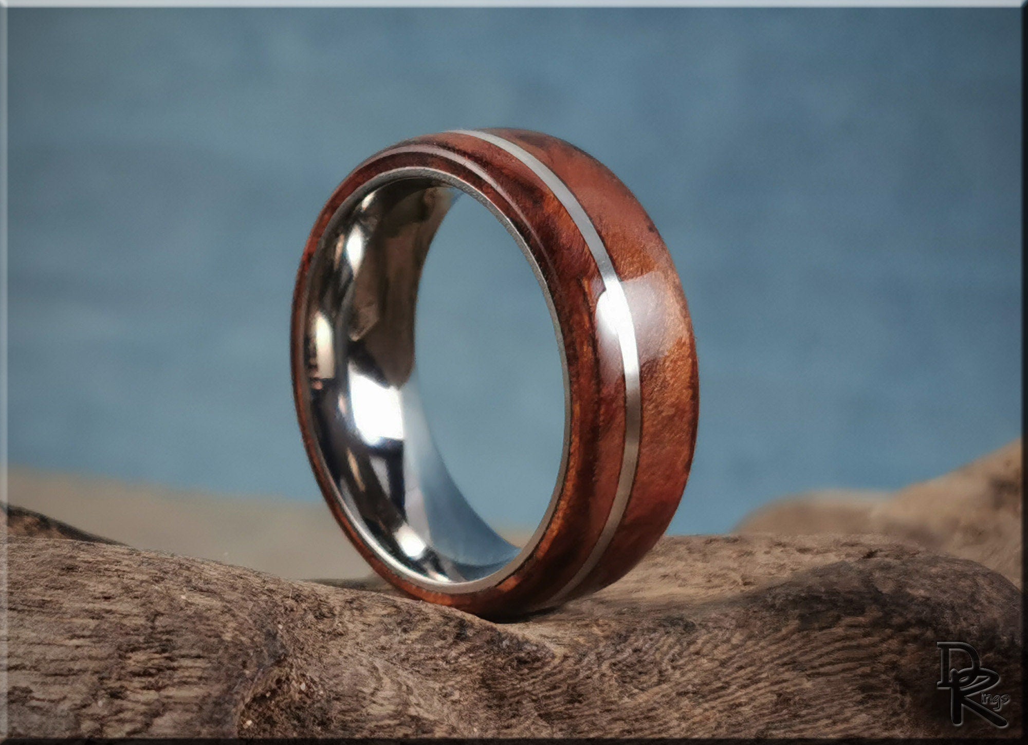DR Rings polished redwood ring with inlay featuring a silver metal band on natural wood background
