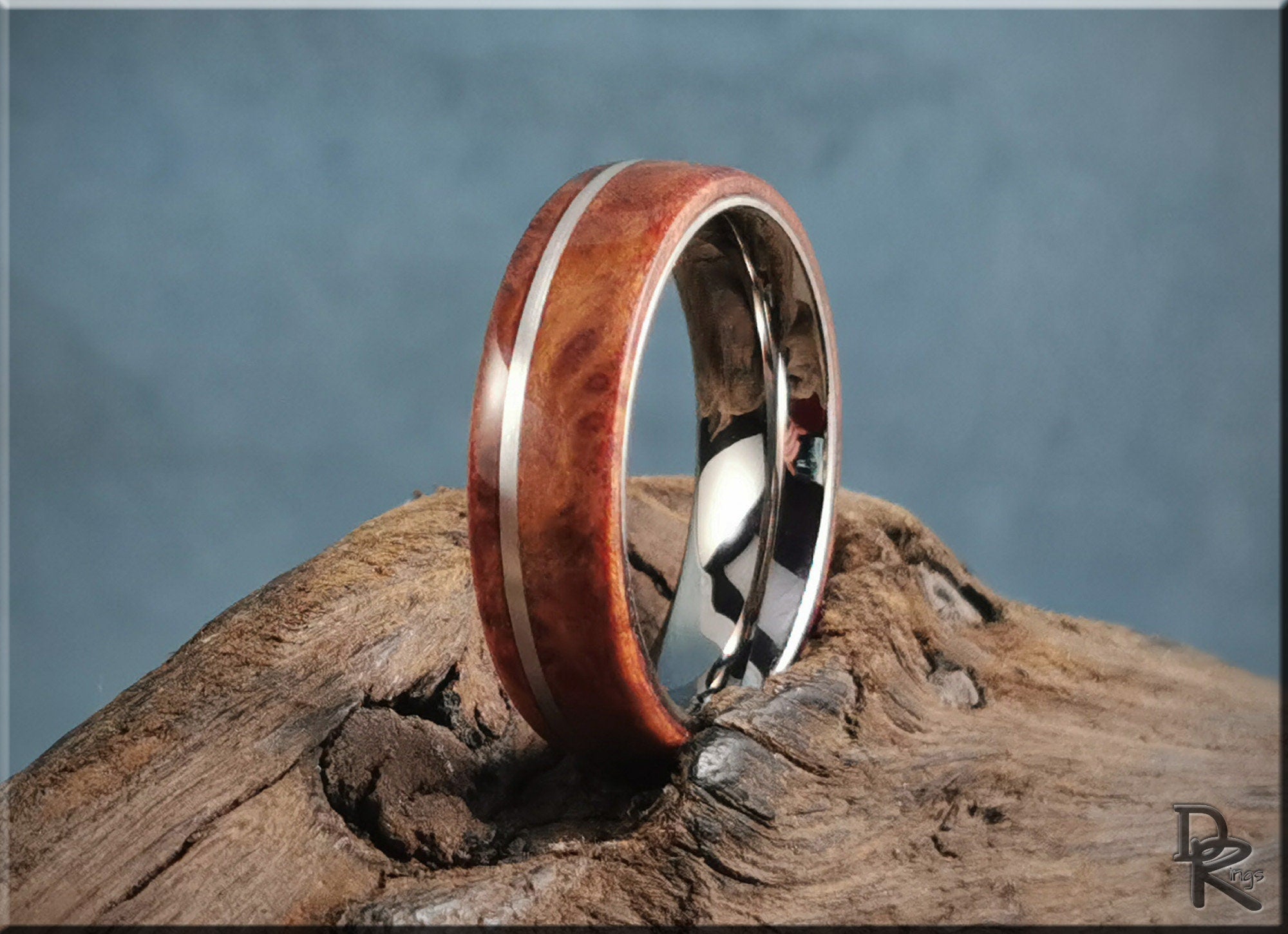 DR Rings redwood ring with inlay featuring polished metal edges on natural wood background