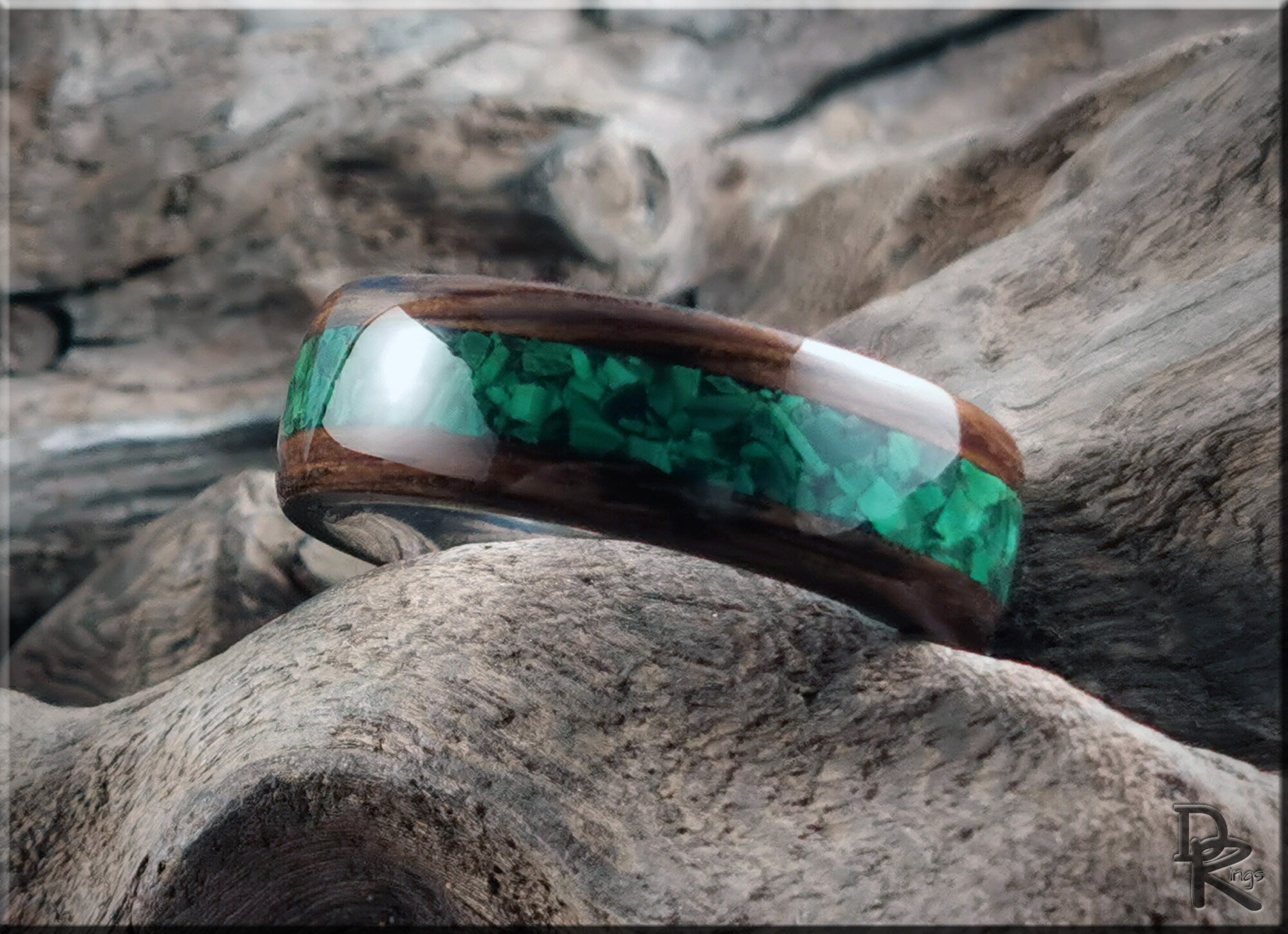 DR Rings band made of ancient bog oak with malachite inlay on a textured wood background