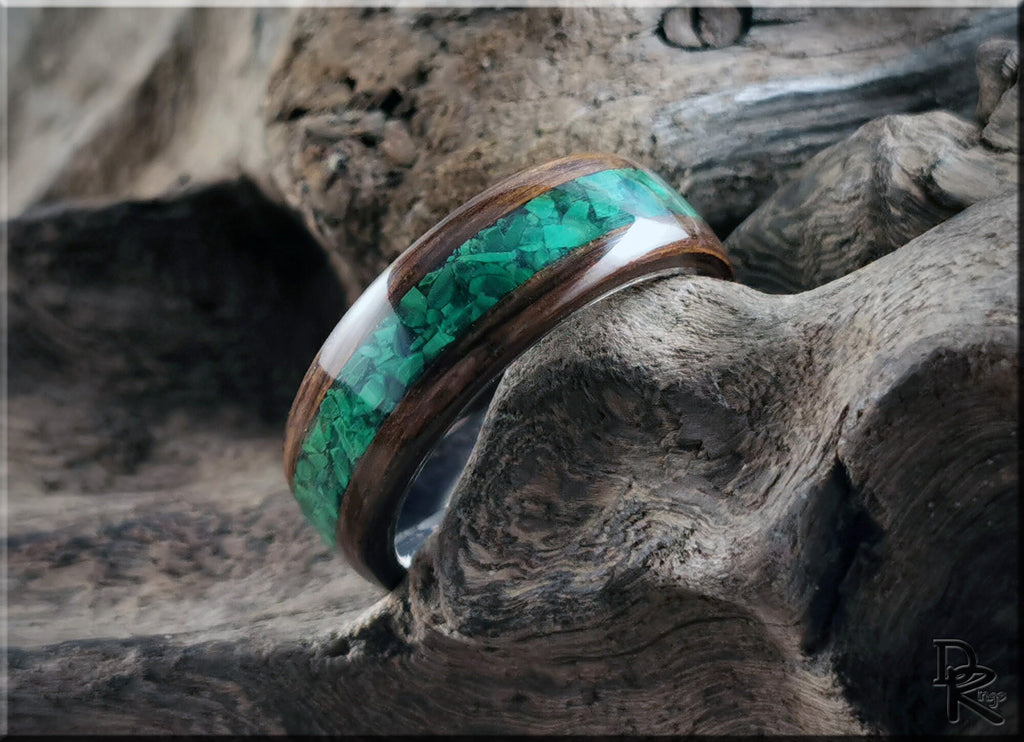 DR Rings handcrafted ring featuring ancient bog oak with malachite inlay on rustic wood background
