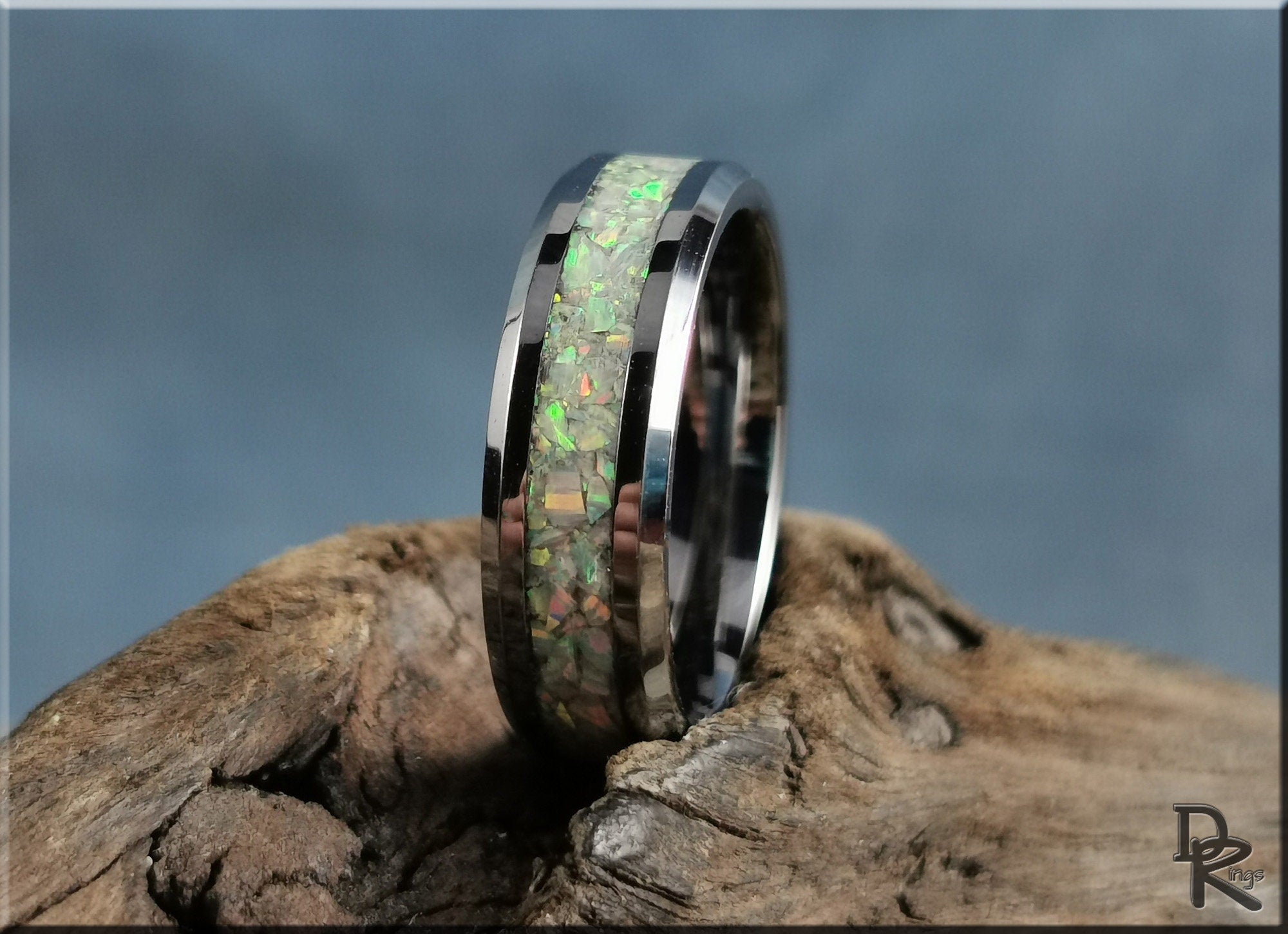 DR Rings silver band with green and orange inlay ring opal set on rustic wood background