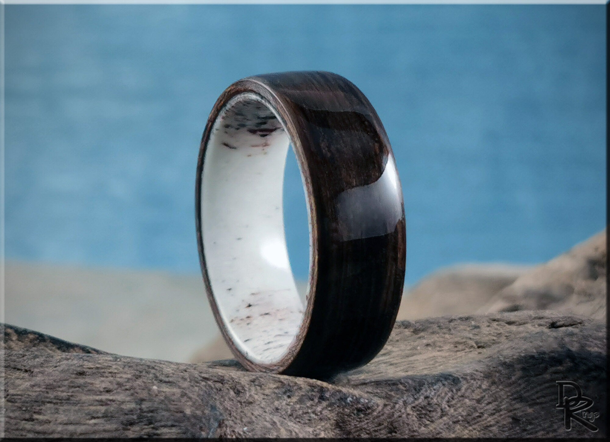 Dark bog oak wood ring with polished finish by DR Rings displayed on natural wood background