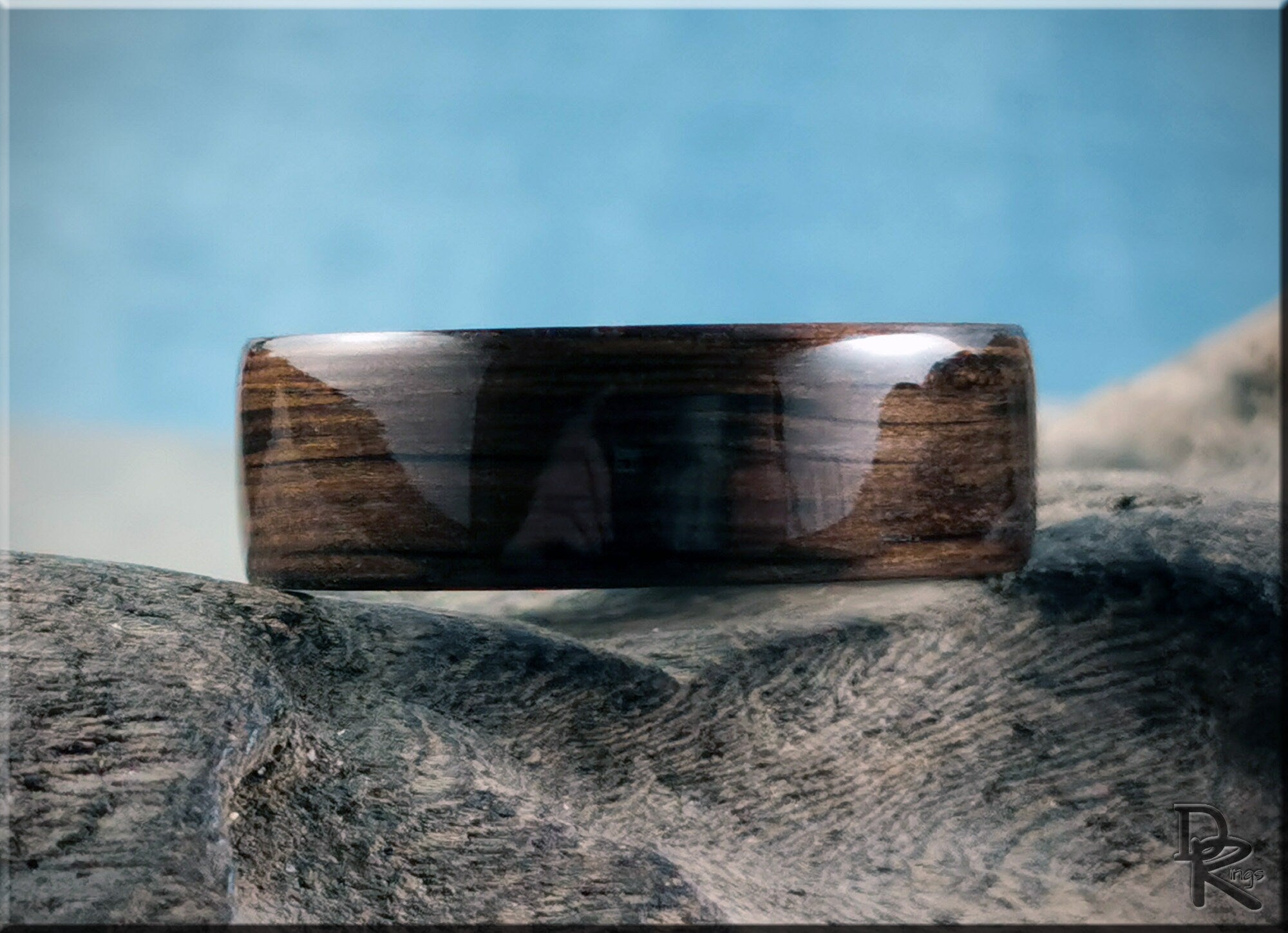 DR Rings polished bog oak wooden ring with smooth finish resting on textured stone surface