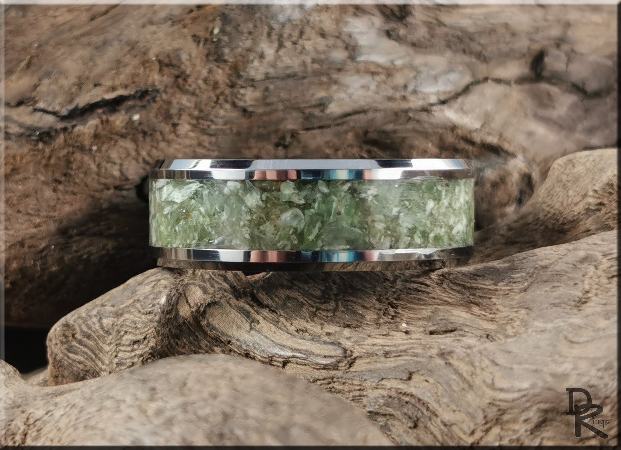 DR Rings tungsten ring with jade inlay featuring a polished silver edge on natural wood background