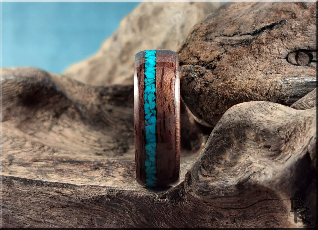 Walnut ring with turquoise inlay by DR Rings displayed on rustic wooden surface