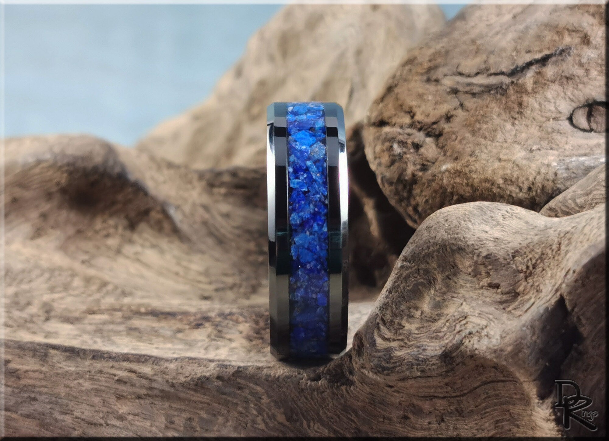 Ceramic ring with lapis inlay featuring vibrant blue stones by DR Rings on rustic wood background