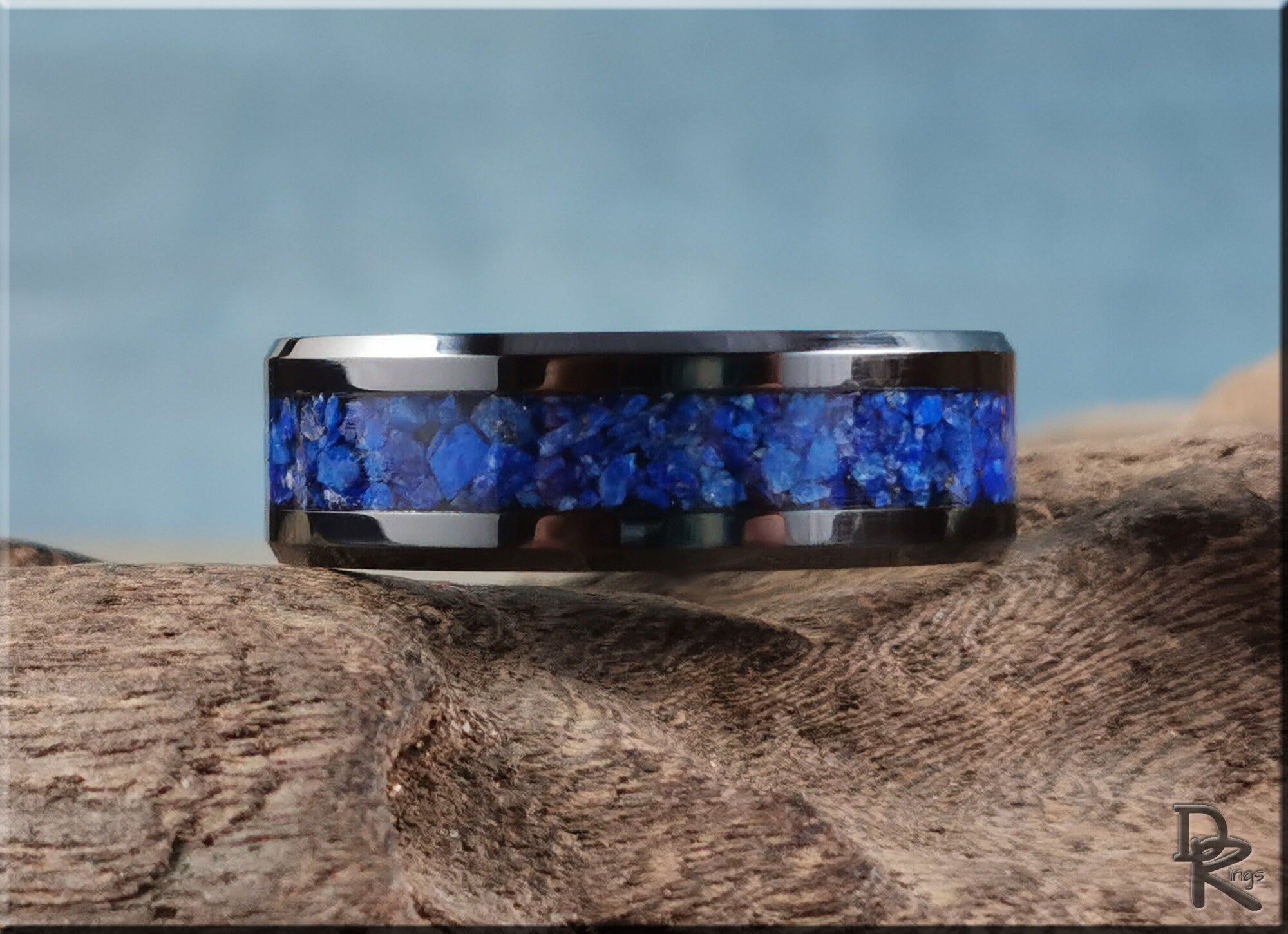 Black ceramic ring with lapis stone inlay by DR Rings displayed on textured wood
