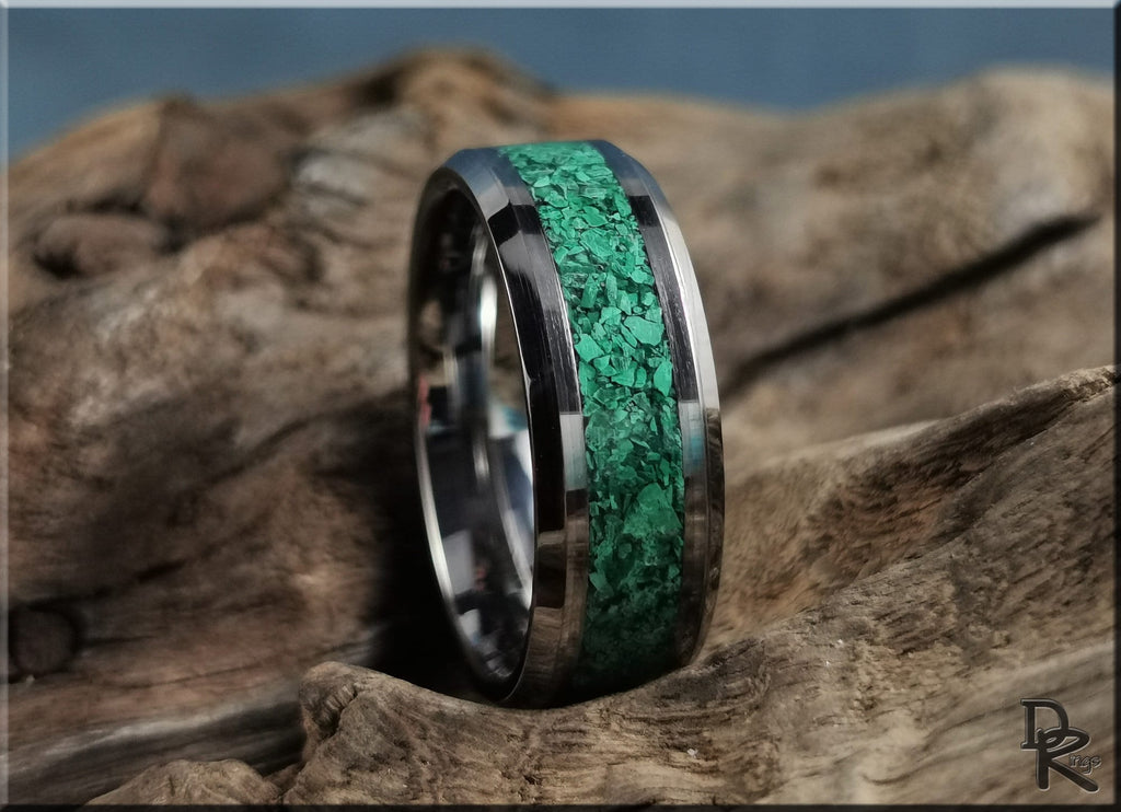 DR Rings tungsten ring with green malachite inlay resting on rustic wood background