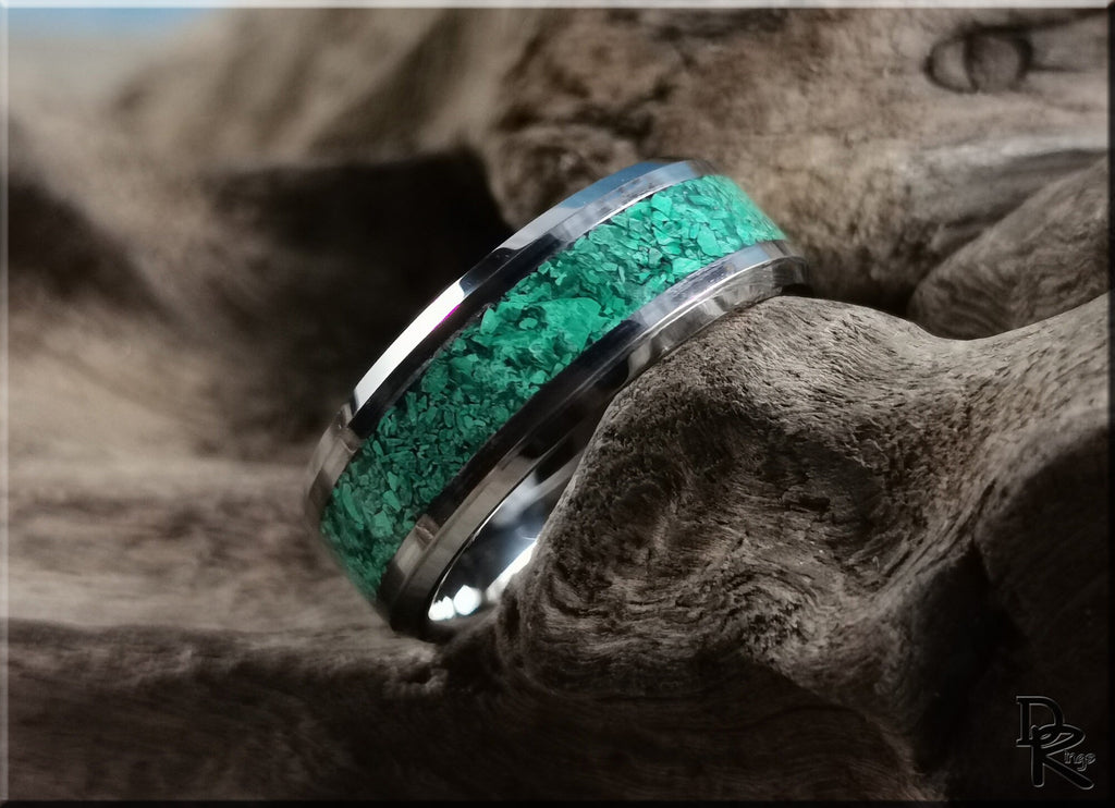 Tungsten ring with green malachite inlay featuring polished silver edges on rustic wood