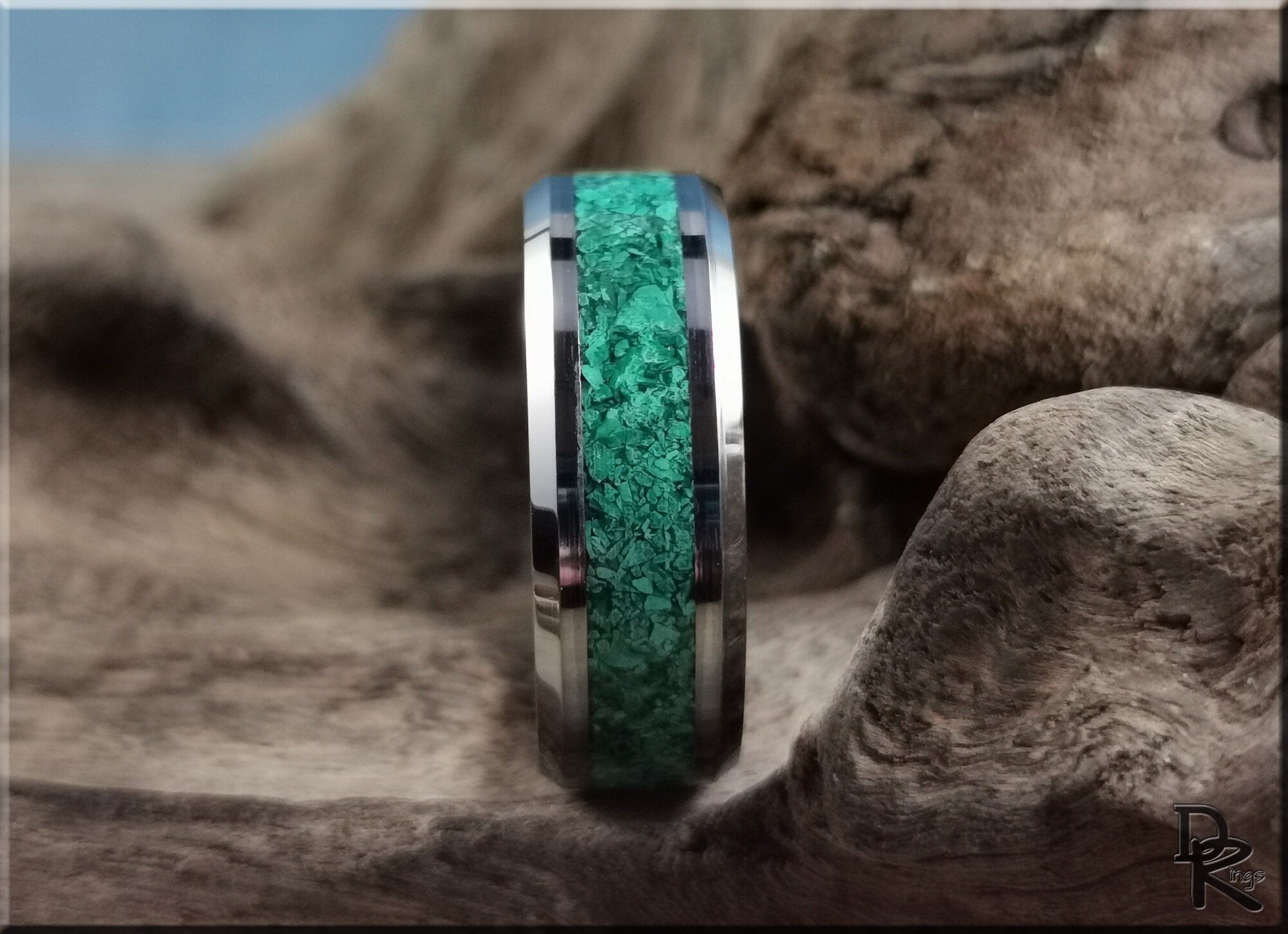 DR Rings tungsten ring with green malachite inlaid band with polished silver edges on wood background