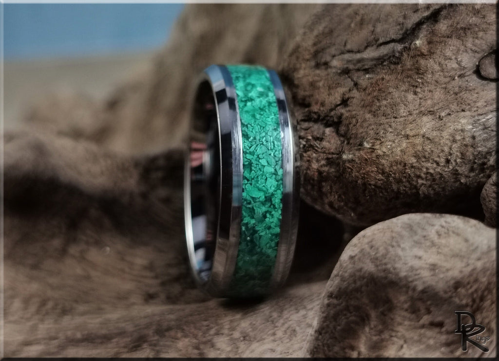 Tungsten ring with green malachite inlay displayed on natural textured rock background