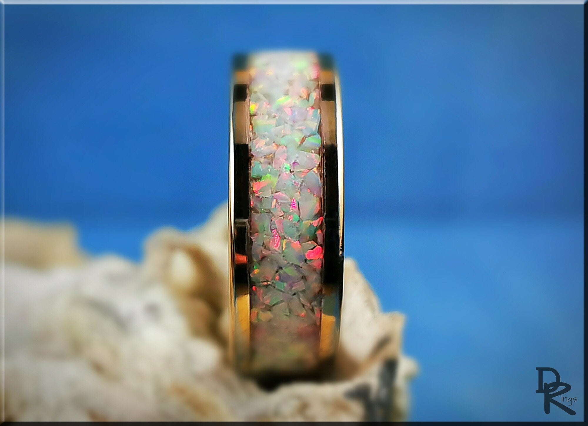 Rose gold ring with opal inlay displaying vibrant multicolor flashes on smooth band
