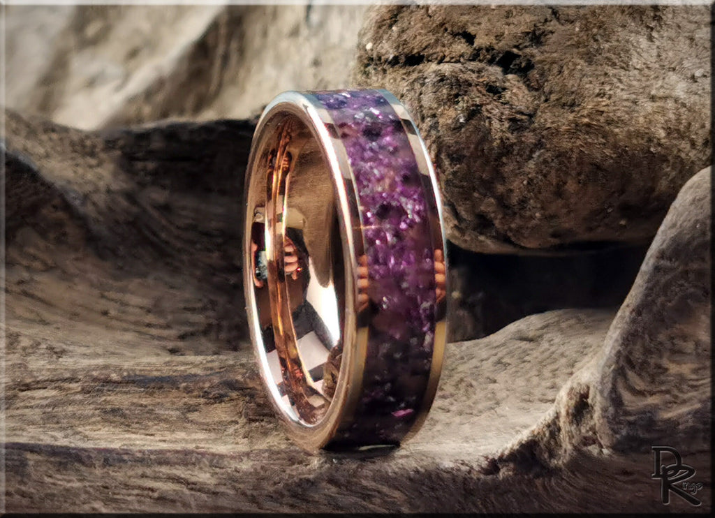 Rose tungsten ring with german glass featuring purple stone inlay on a rustic wood background