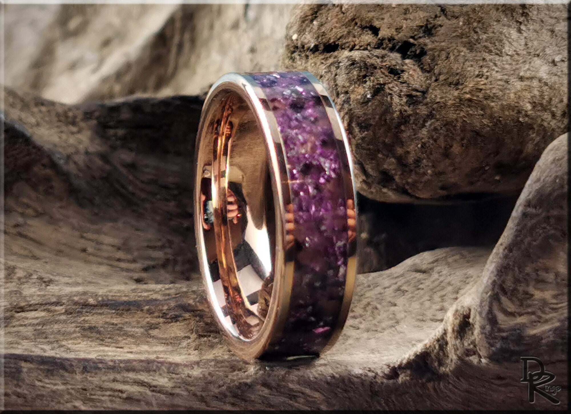 Rose tungsten ring with german glass featuring purple stone inlay on a rustic wood background