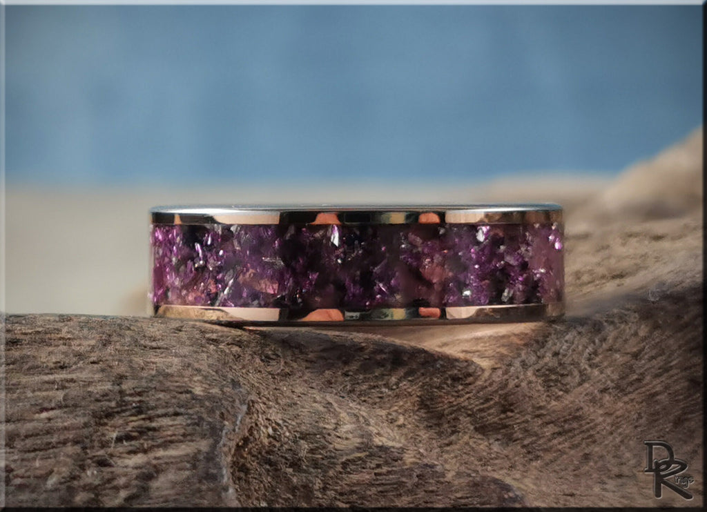 Rose tungsten ring with german glass featuring purple crushed glass inlay on a natural wooden surface