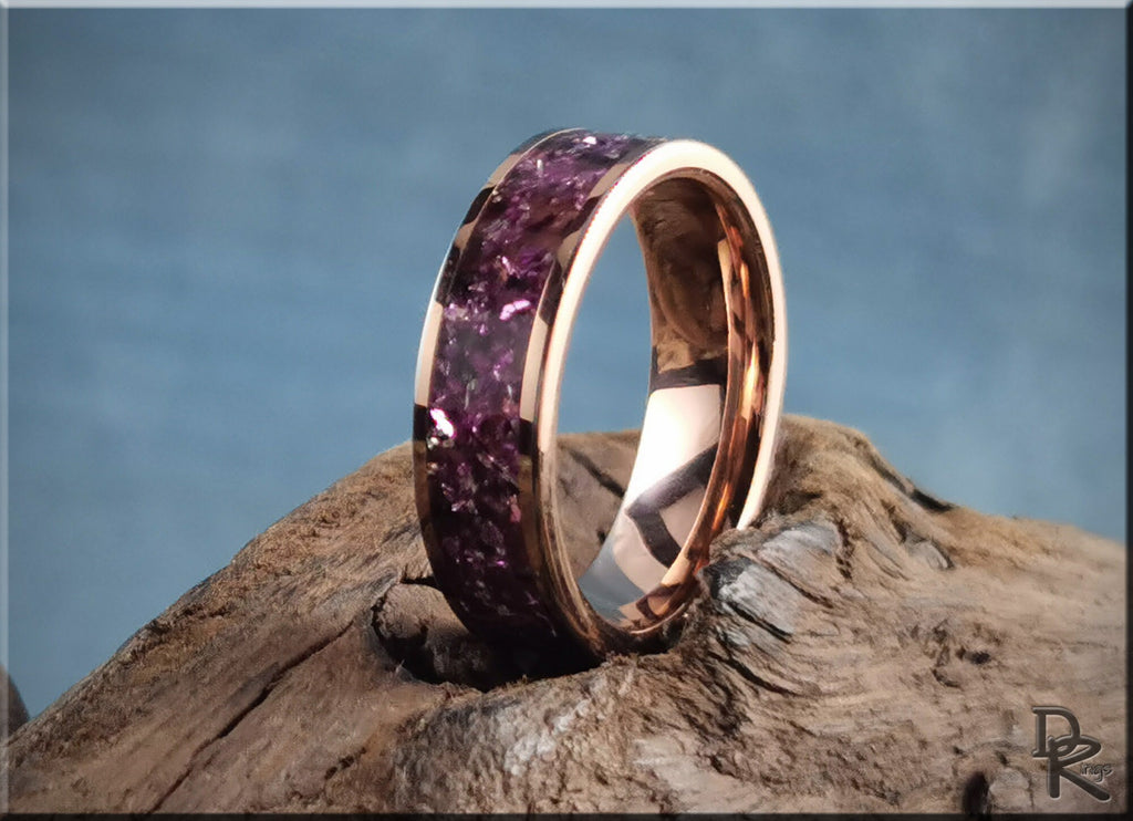 Rose tungsten ring with german glass featuring purple glass inlay on wooden background