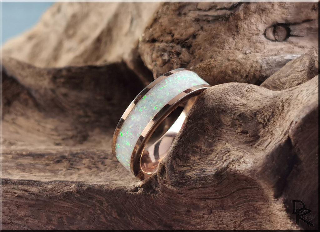 Rose tungsten ring with glow inlay featuring a polished rose gold finish on textured wood background
