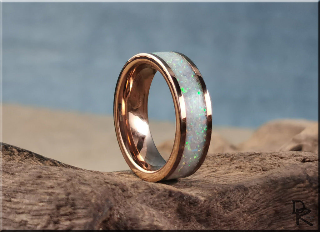 Rose tungsten ring with glow inlay featuring iridescent opal design on wooden surface