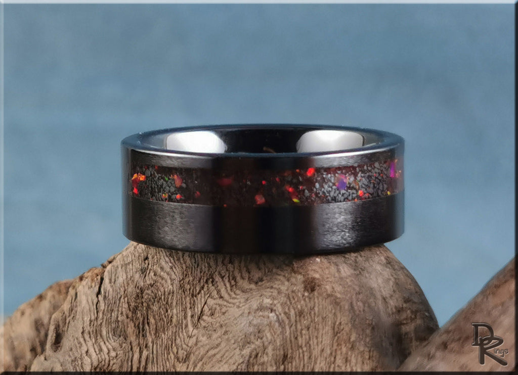 DR Rings black ring opal with vibrant red and purple opal inlay on wood background