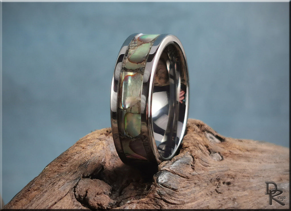 DR Rings super titanium ring with abalone shell inlay on rustic wood background