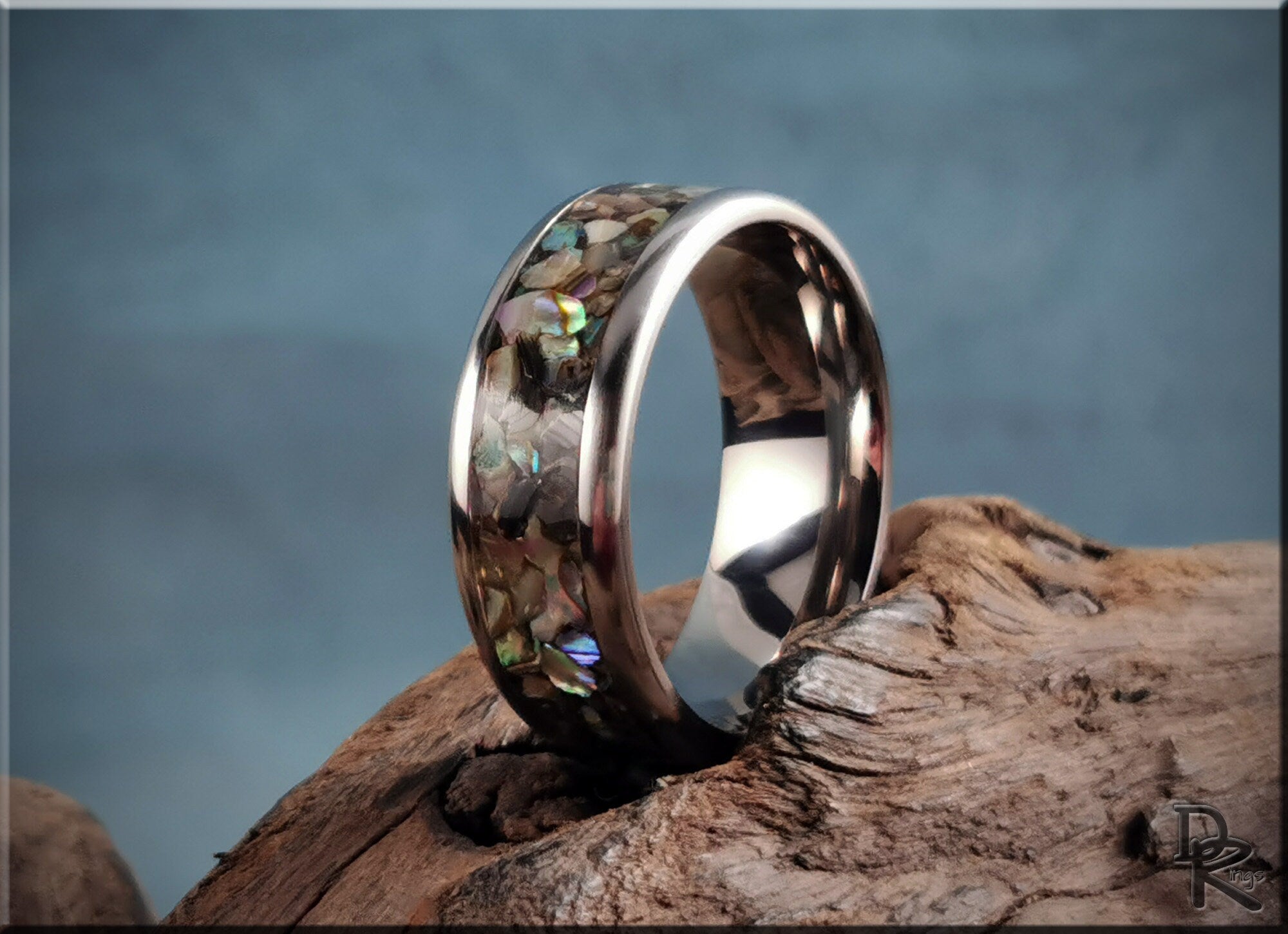 DR Rings titanium ring with abalone inlay on rustic wood with blue background