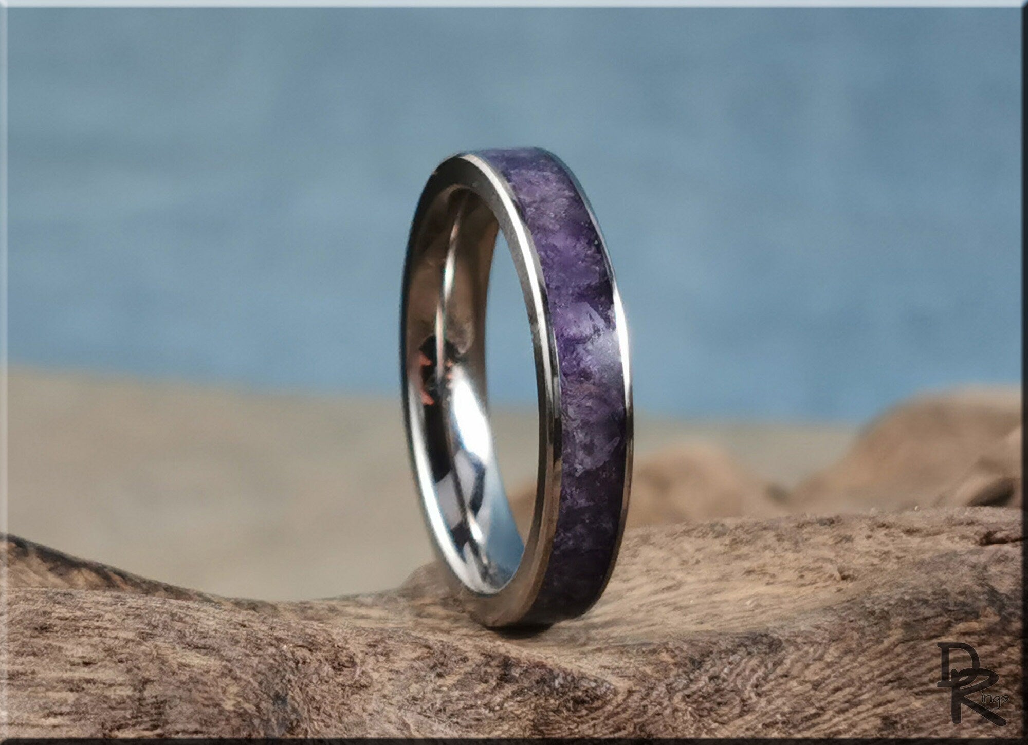 DR Rings titanium ring with amethyst inlay on rustic wooden surface with blurred background
