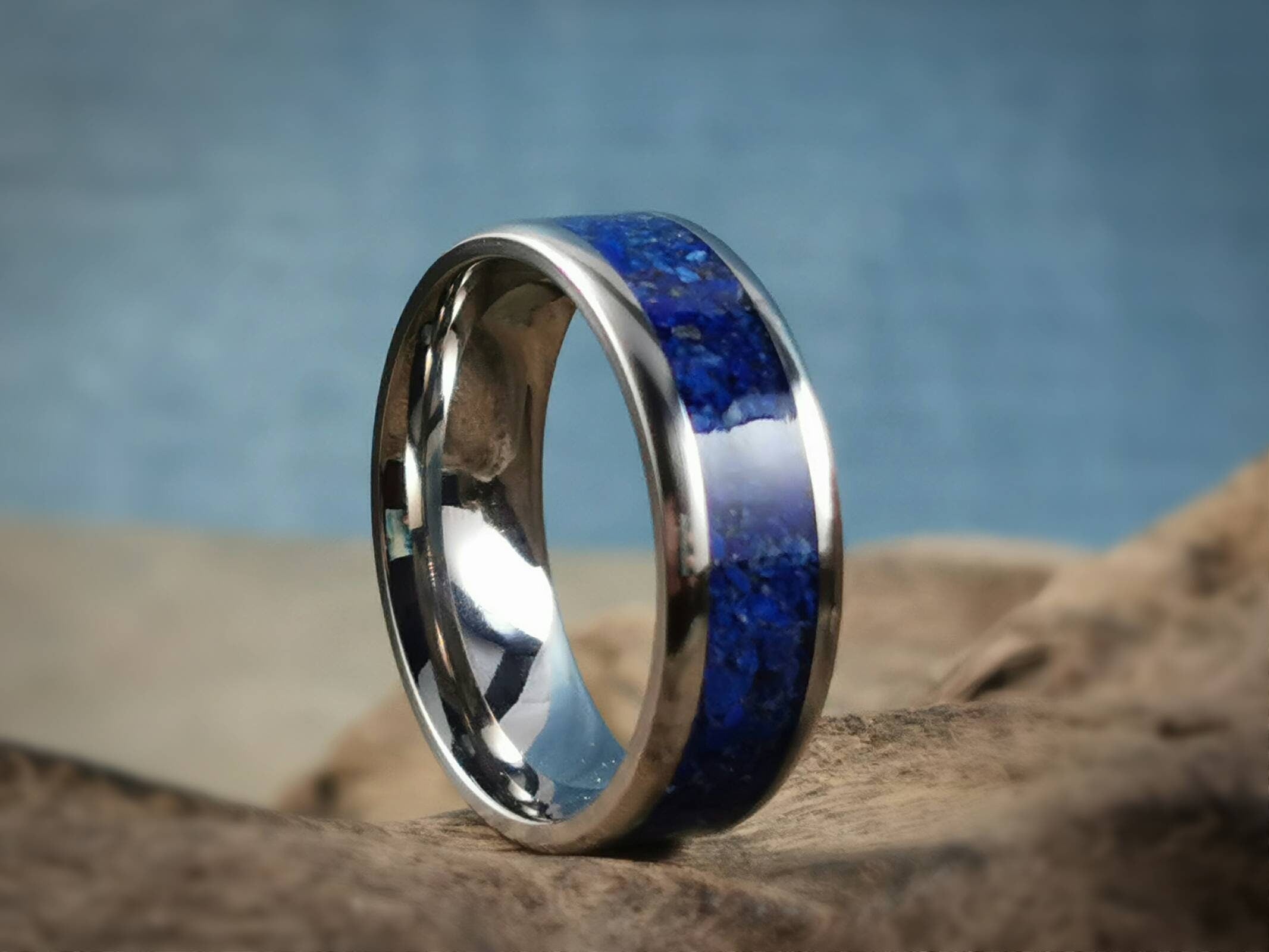 DR Rings titanium ring with lapis blue stone inlay on a natural rock background