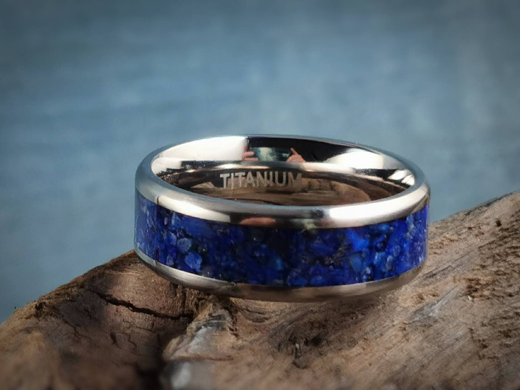 DR Rings titanium ring with lapis blue stone inlay on rustic wooden surface background