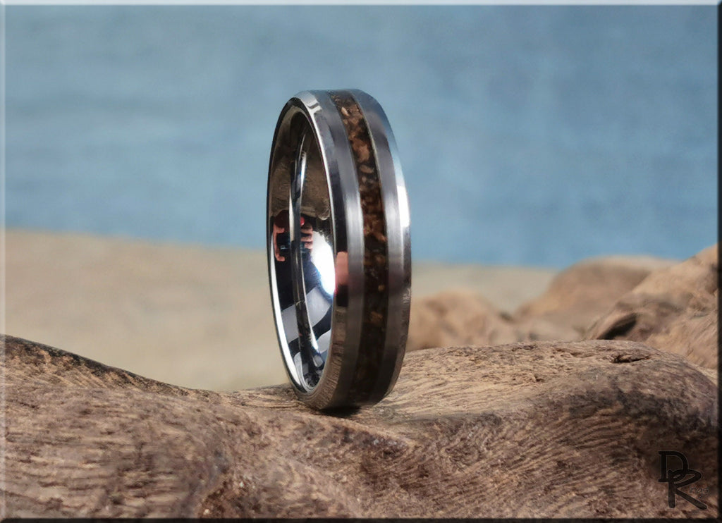 Tungsten carbide ring with inlay featuring a dark wood design from DR Rings on natural textured background