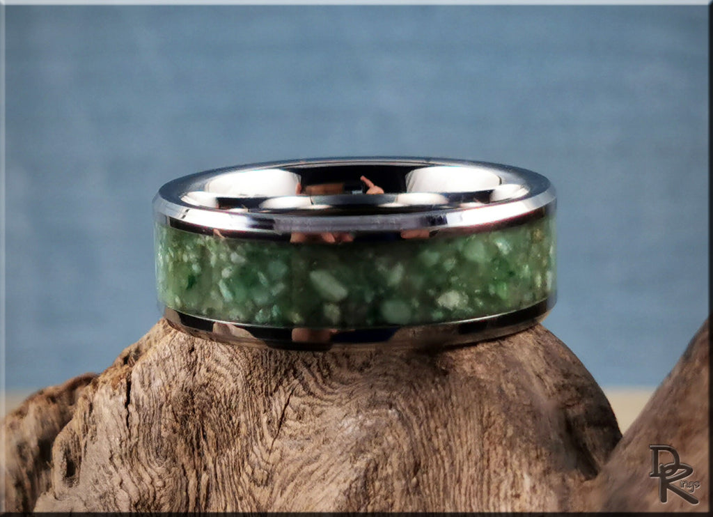 Tungsten carbide ring with inlay featuring a green stone design and polished silver edges