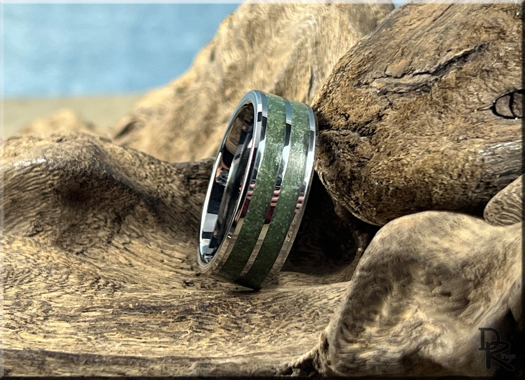 DR Rings tungsten ring carbide with emerald inlay resting on textured natural wood surface