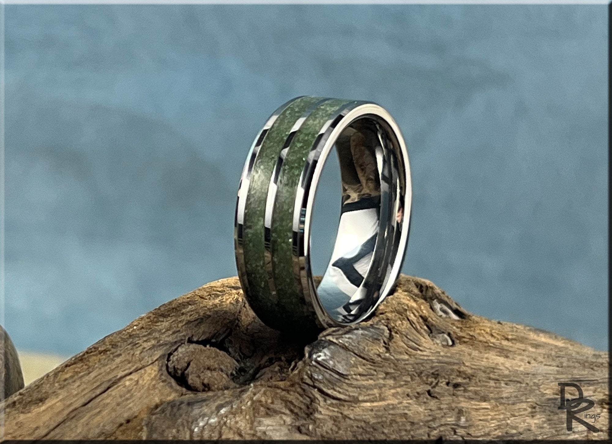 DR Rings tungsten ring carbide with emerald inlay on a rustic wooden surface