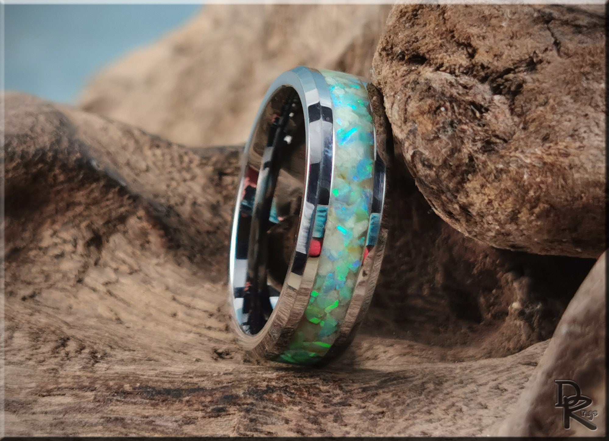 Tungsten ring with opal and glow inlay by DR Rings displayed on natural wood background