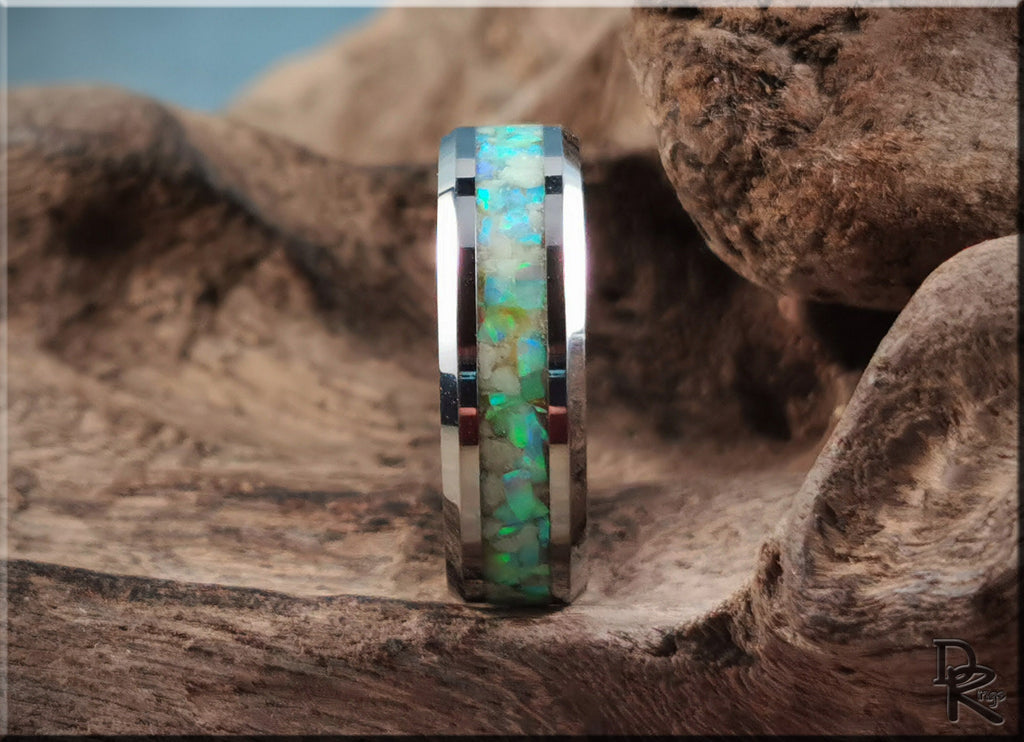 Tungsten ring with opal and glow inlay by DR Rings displayed on rustic wood background