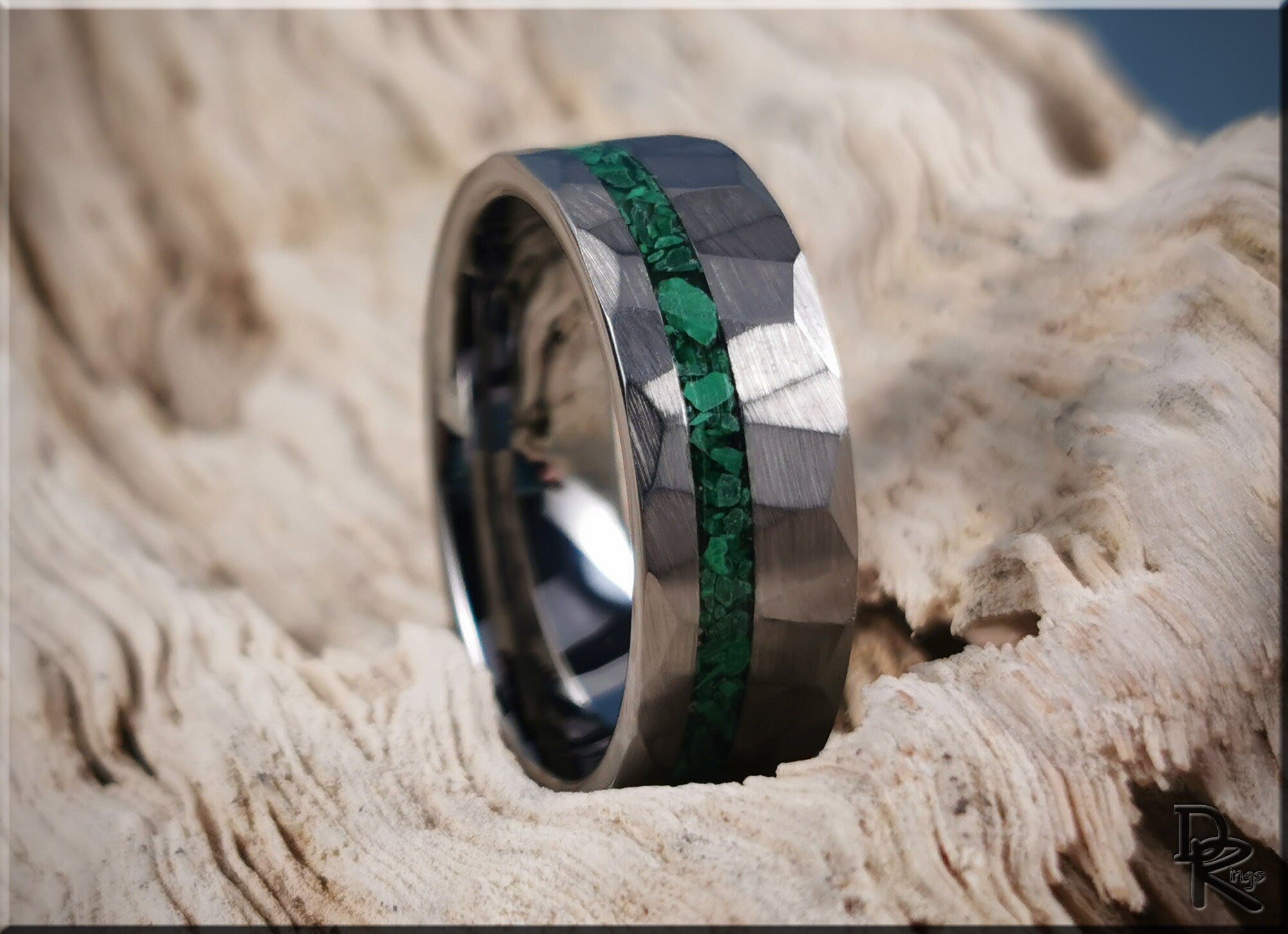 Hammered tungsten ring with malachite green stone inlay from DR Rings on textured surface